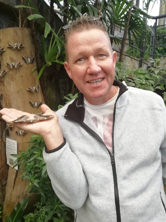 A man holding a giant butterfly at Mariposario del Drago, Tenerife